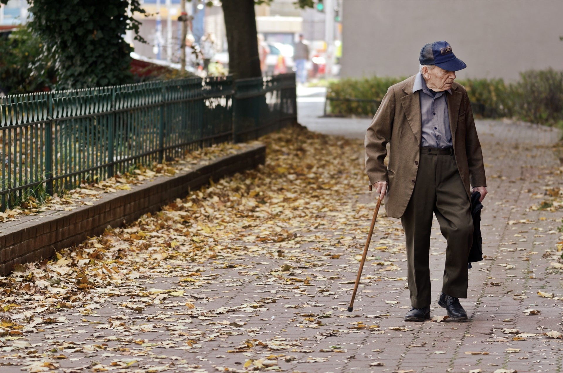 photo-of-elderly-man-walking-on-pavement